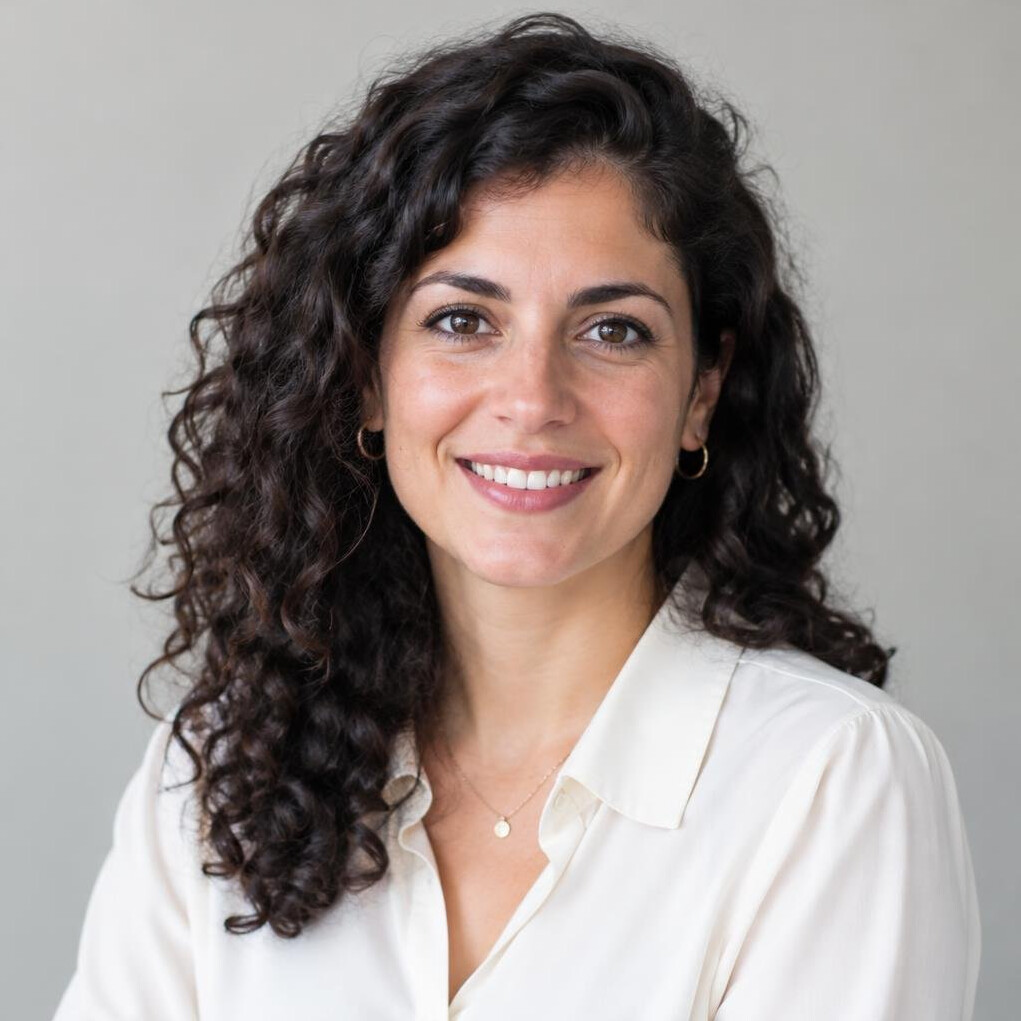 Portrait of a woman with dark curly hair smiling